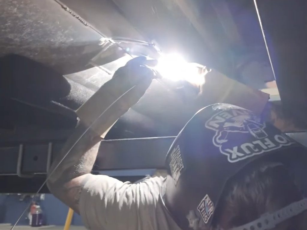 Technician welding the underside of an aluminum pontoon