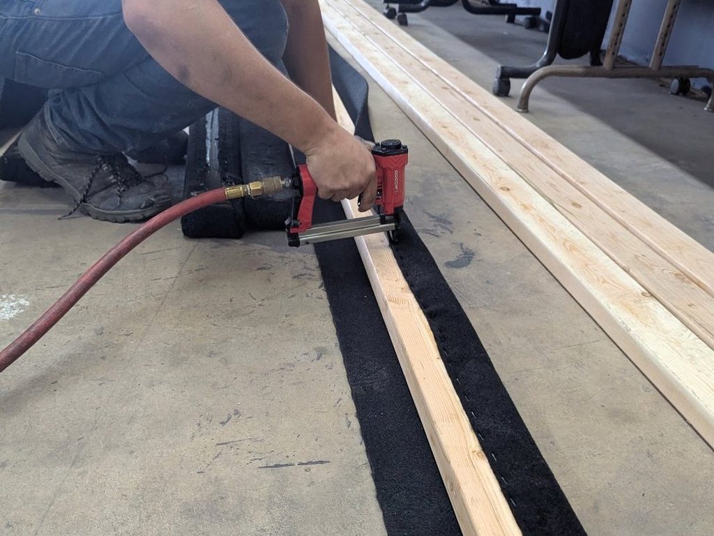 Stapling marine carpet onto a new trailer bunk board